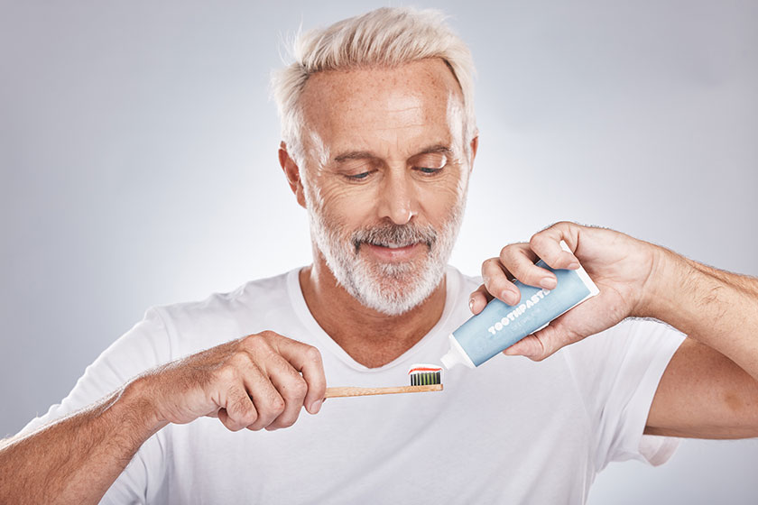 Face toothpaste senior man toothbrush studio isolated gray background hygiene Face toothpaste senior man toothbrush studio isolated gray background hygiene
