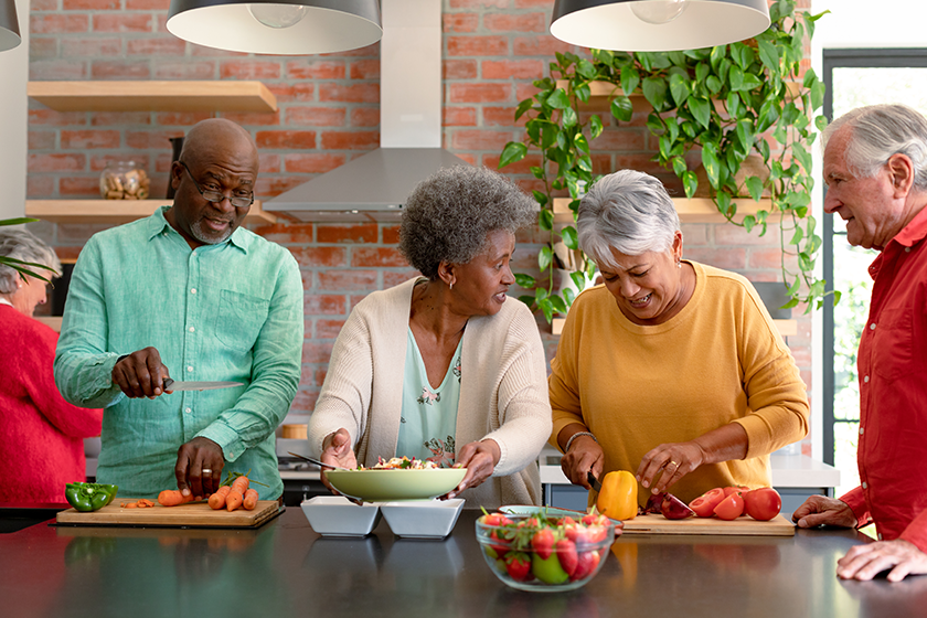 happy diverse senior male female preparing dinner