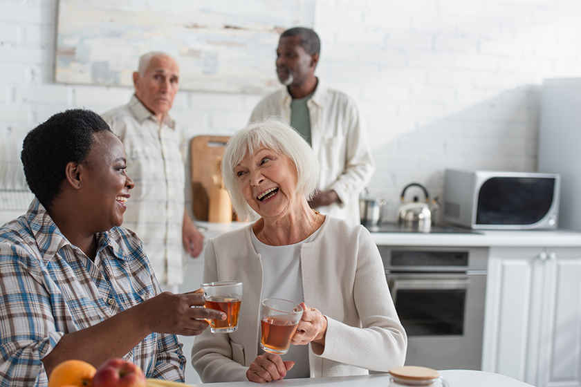 happy senior interracial women holding tea