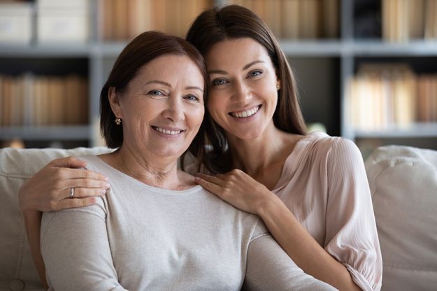 Head shot portrait mature mother and daughter hugging at home Head shot portrait mature mother and daughter hugging at home