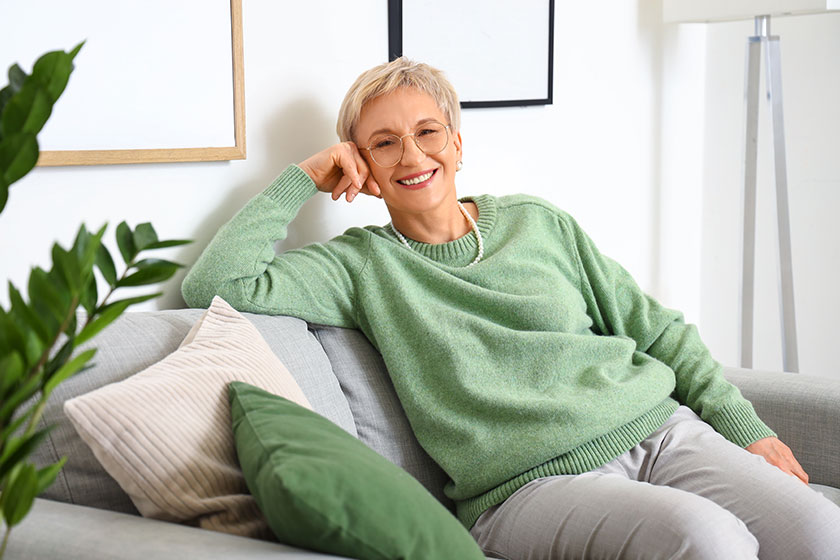 Mature woman sitting sofa home