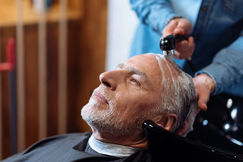 old man during washing his hair in barber shop old man during washing his hair in barber shop