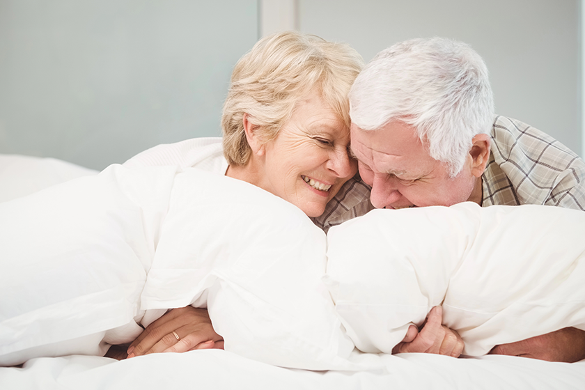 playful senior couple resting in bed
