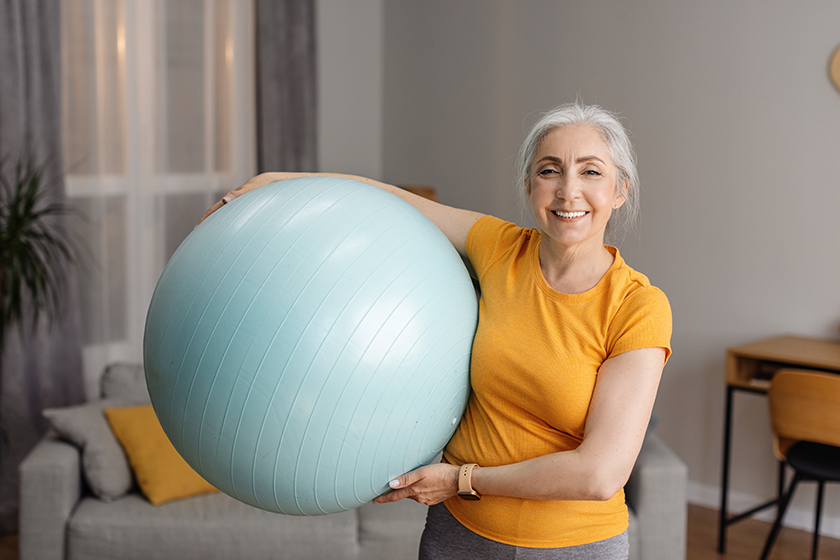 portrait positive senior woman holding fitness ball