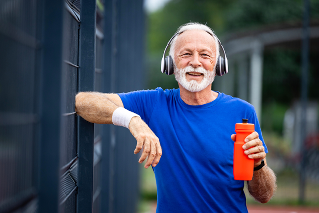 portrait senior man holding water bottle proudly standing