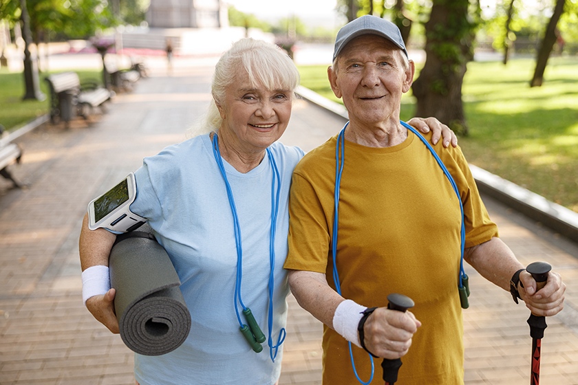 positive mature woman and man with sports equipment