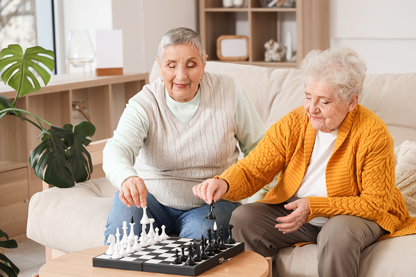 senior female friends playing chess
