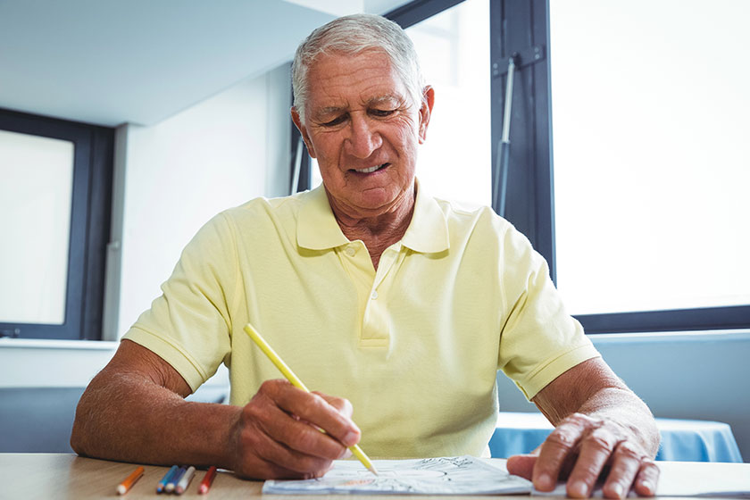 Senior man using a colouring book Senior man using a colouring book