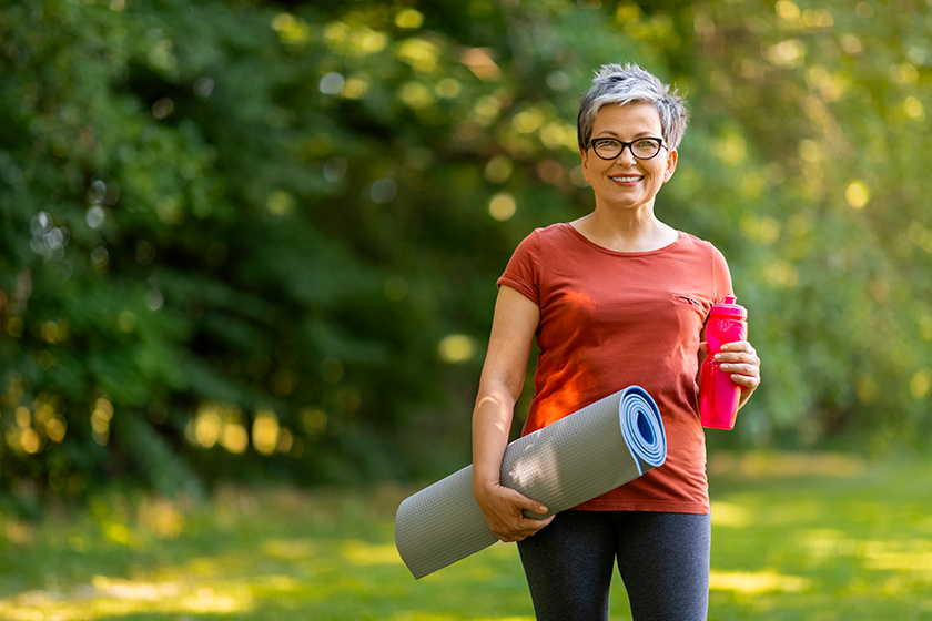 smiling senior woman holding water bottle yoga mat smiling senior woman holding water bottle yoga mat
