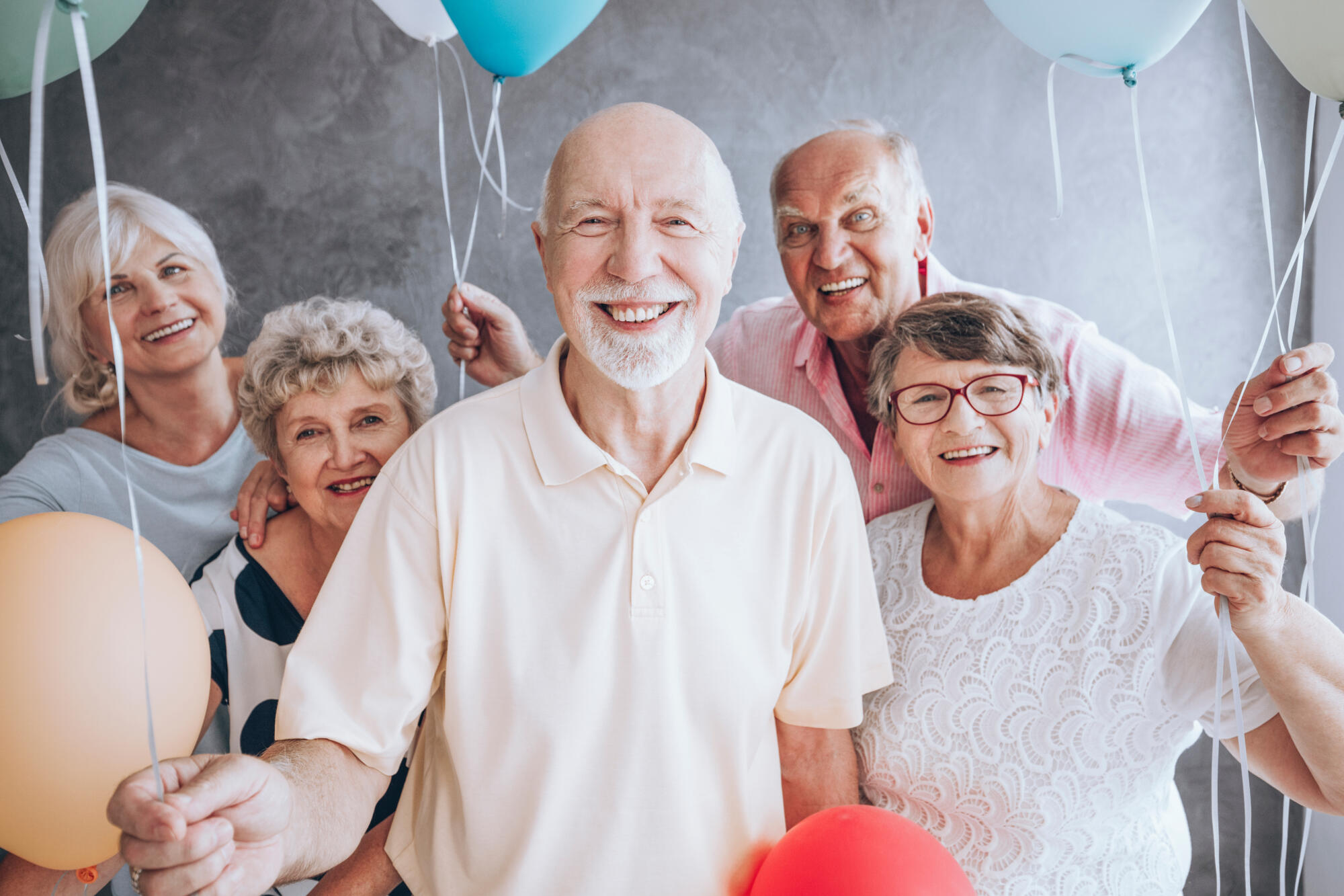 Smiling,Elderly,Man,And,His,Friends,With,Balloons,Enjoying,His