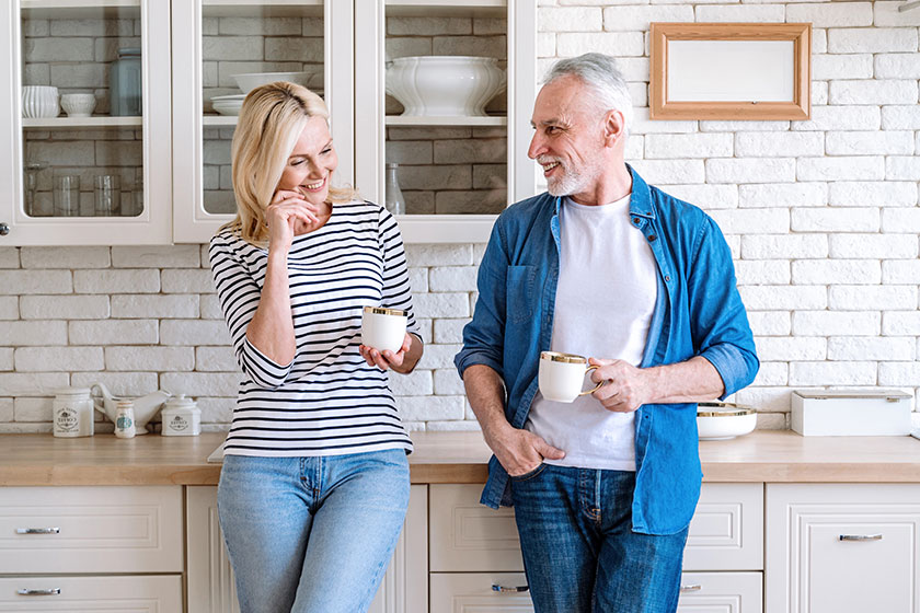 Mature woman man spending time together standing home kitchen drink Mature woman man spending time together standing home kitchen drink