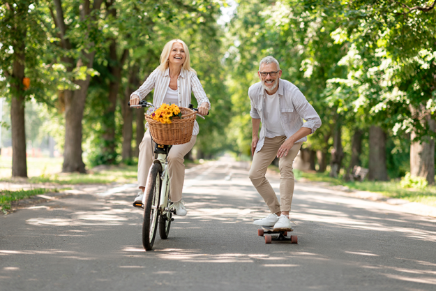modern pensioners happy senior couple riding bike skateboard park cheerful
