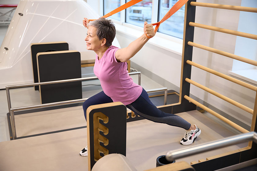 Smiling middle aged caucasian woman wearing sportswear stretching rope injury Smiling middle aged caucasian woman wearing sportswear stretching rope injury