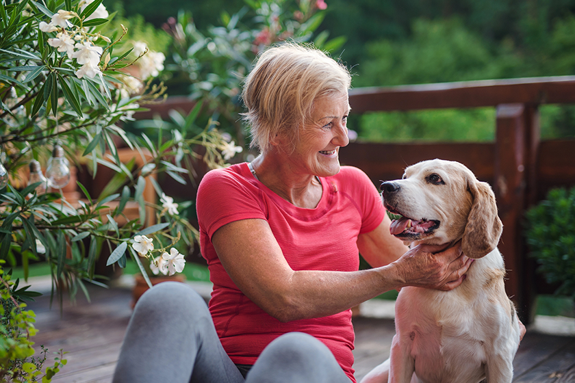a senior woman with dog outdoors