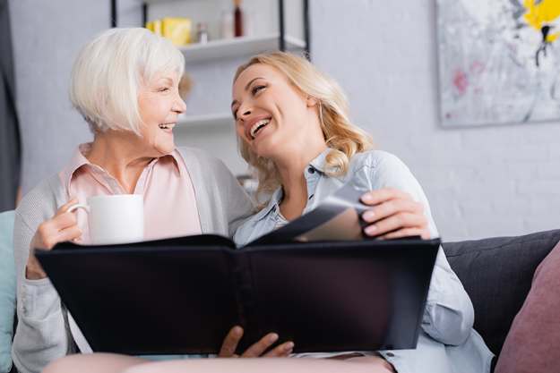 cheerful women cup holding photo album