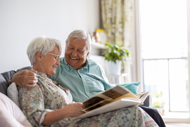elderly couple looking photo album