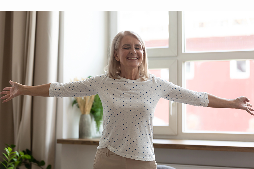 happy mature woman standing with arms outstretched happy mature woman standing with arms outstretched