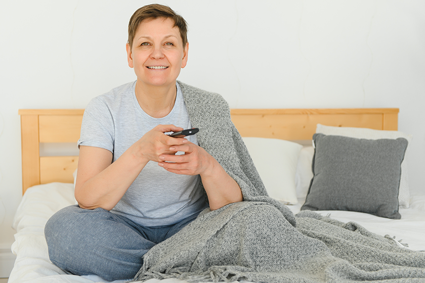 middle aged woman sitting sofa turning remote middle aged woman sitting sofa turning remote