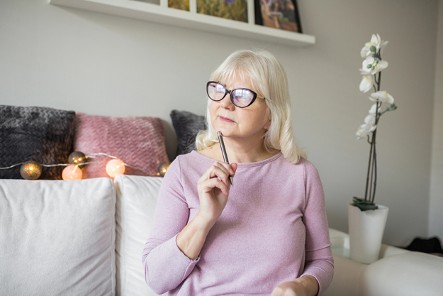 senior lady in glasses holding ball pen senior lady in glasses holding ball pen