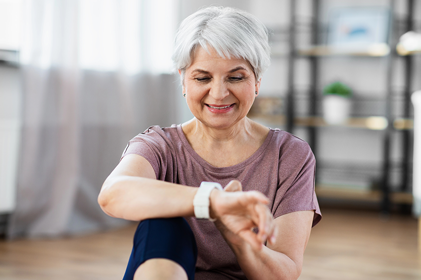 smiling senior woman with fitness tracker