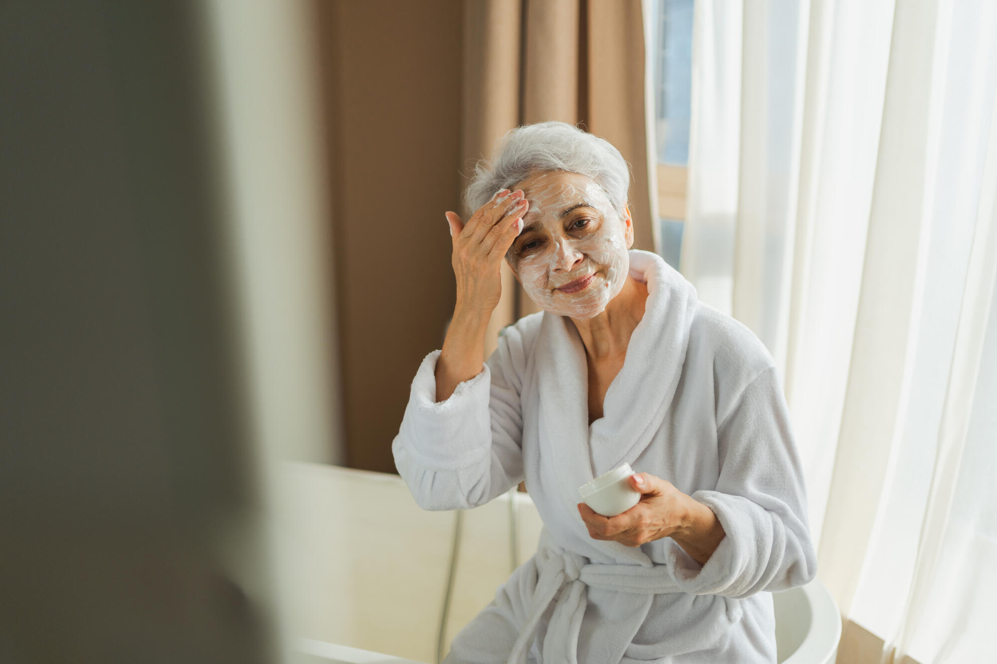 Mature adult old woman applyin Mature adult old woman applyin