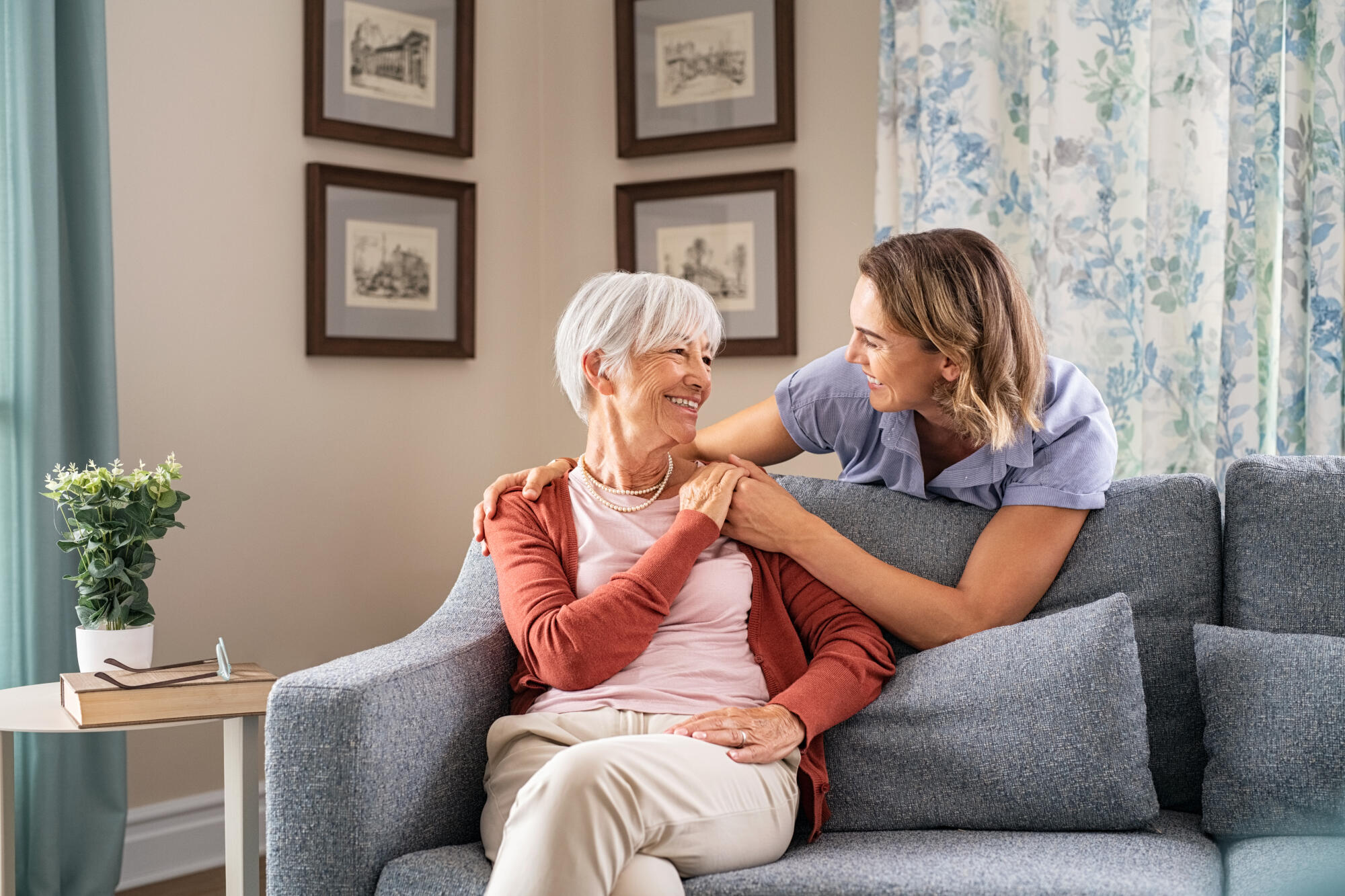 Smiling,Adult,Daughter,Embracing,From,Behind,Old,Mother,Sitting,On