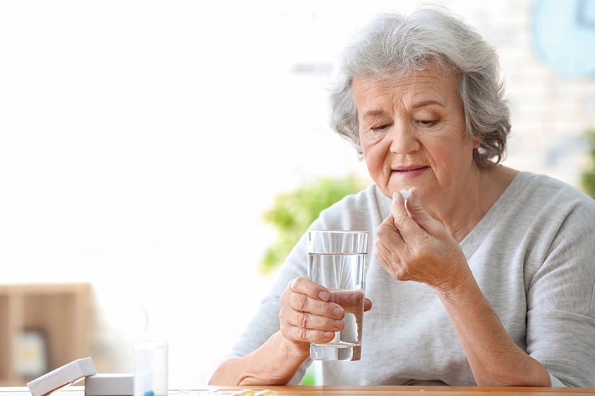 elderly woman taking pill elderly woman taking pill