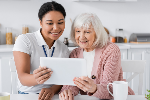 joyful multiracial social worker holding digital tablet