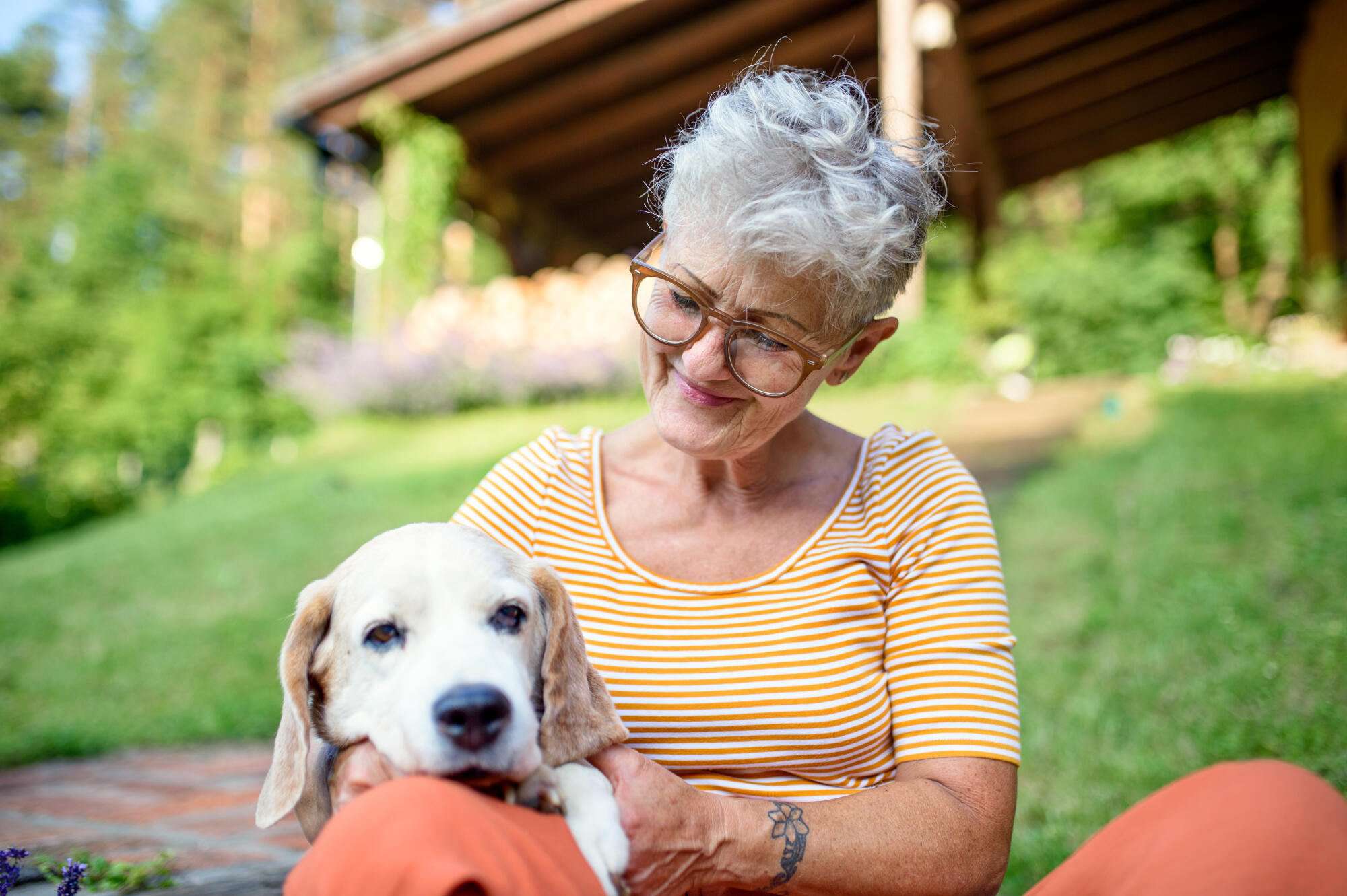 Portrait,Of,Senior,Woman,Sitting,Outdoors,In,Garden,,Pet,Dog