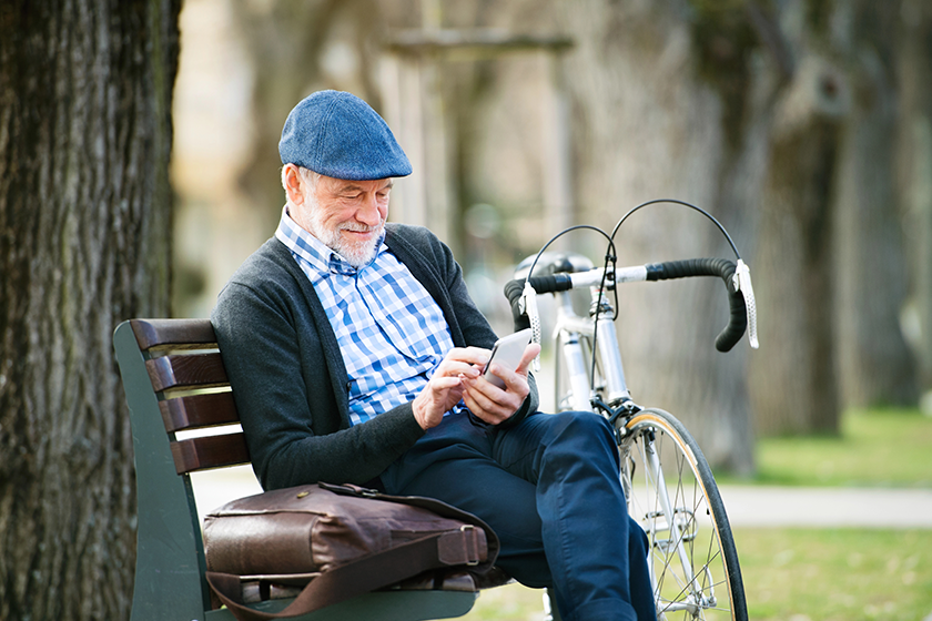 senior man with bicycle in town holding smart phone senior man with bicycle in town holding smart phone