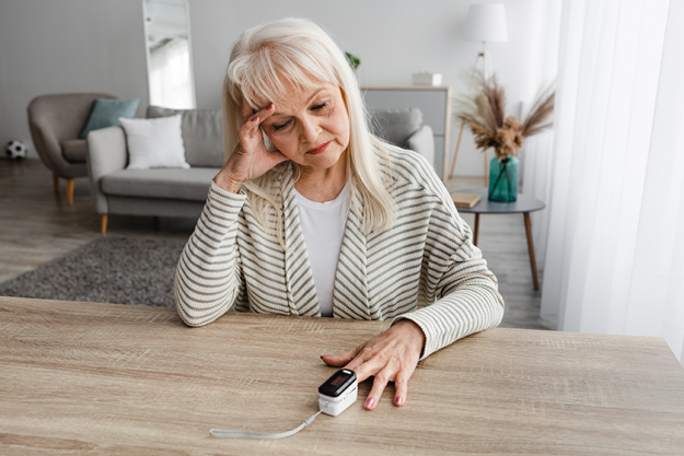 senior woman using oximeter at home