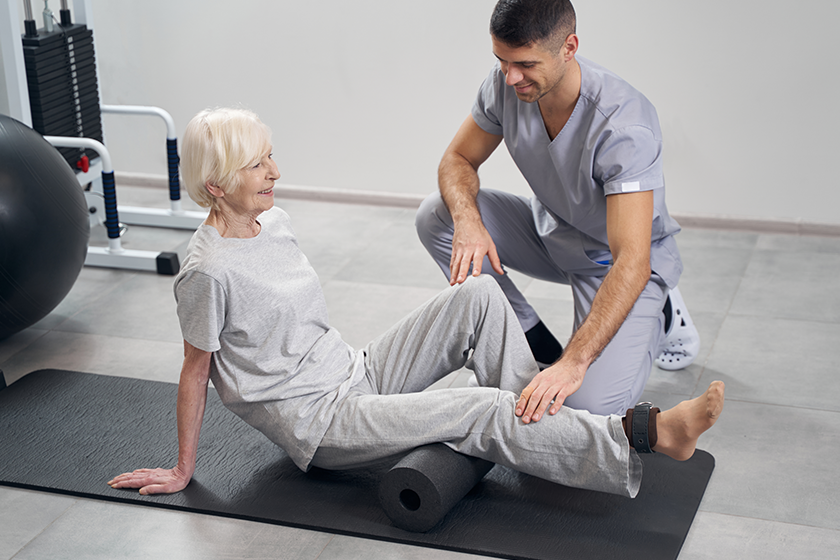 therapist adjusting aging female leg therapist adjusting aging female leg