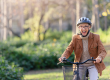 cheerful elderly woman riding bicycle