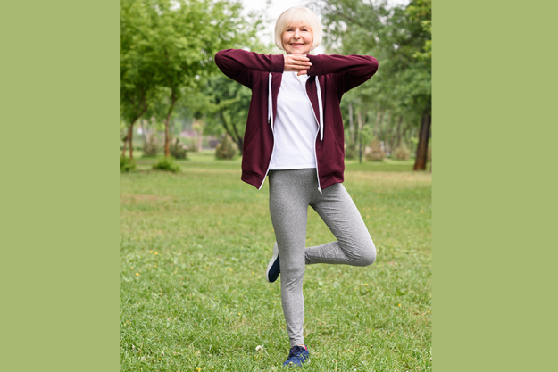 elderly woman tree pose practicing yoga