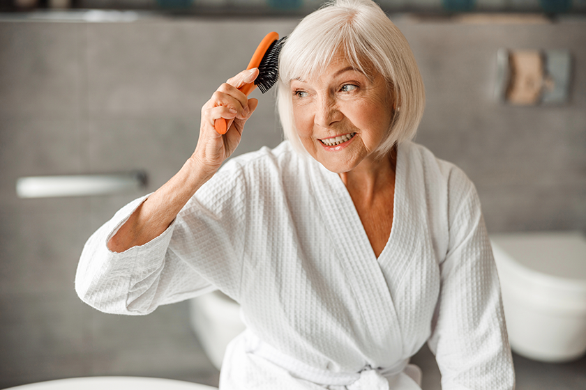 lovely old woman brushing hair