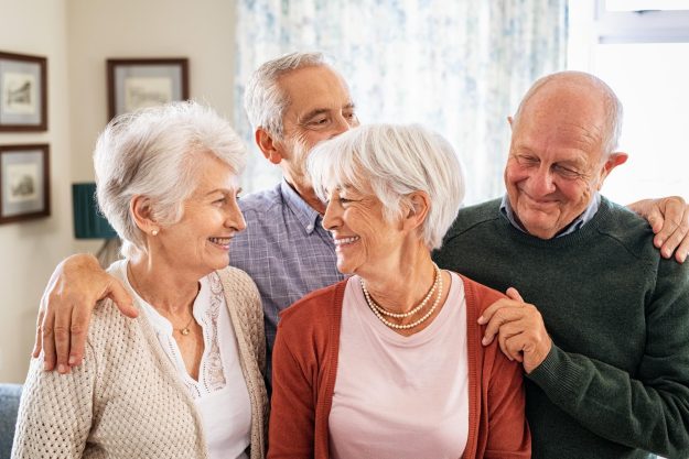 Happy,Senior,Couple,With,Friends,Embracing,And,Smiling,At,Home. Happy,Senior,Couple,With,Friends,Embracing,And,Smiling,At,Home.