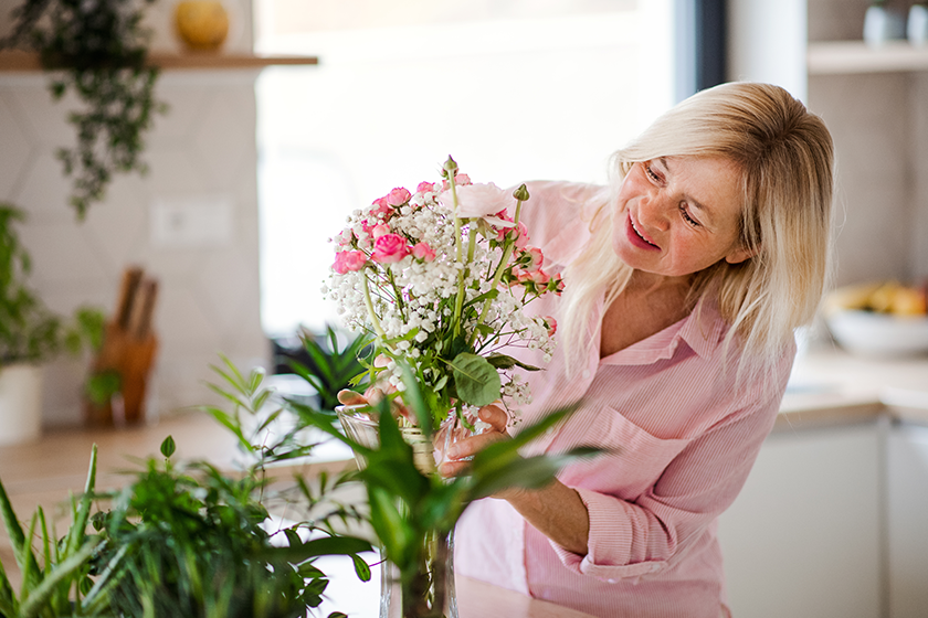 portrait of senior woman arranging flowers