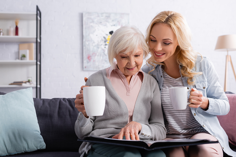 smiling elderly woman cup looking photo album smiling elderly woman cup looking photo album