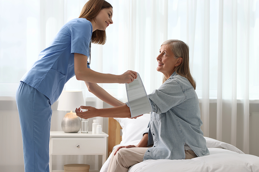 smiling healthcare worker measuring patient blood pressure smiling healthcare worker measuring patient blood pressure