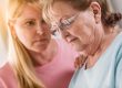 Young Adult Woman Consoles Sad Senior Adult Female.