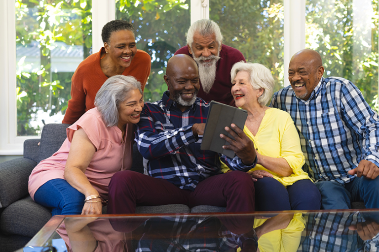 happy diverse group senior friends using tablet