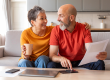 happy senior spouses checking financial documents