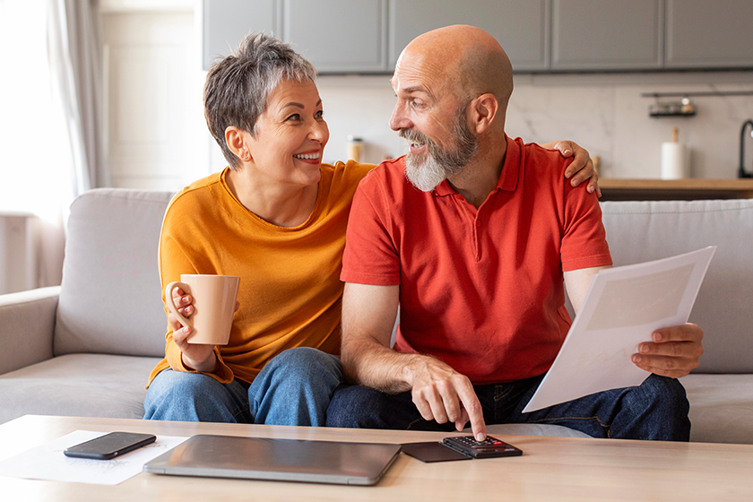 happy senior spouses checking financial documents
