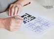 mature woman playing sudoku puzzle