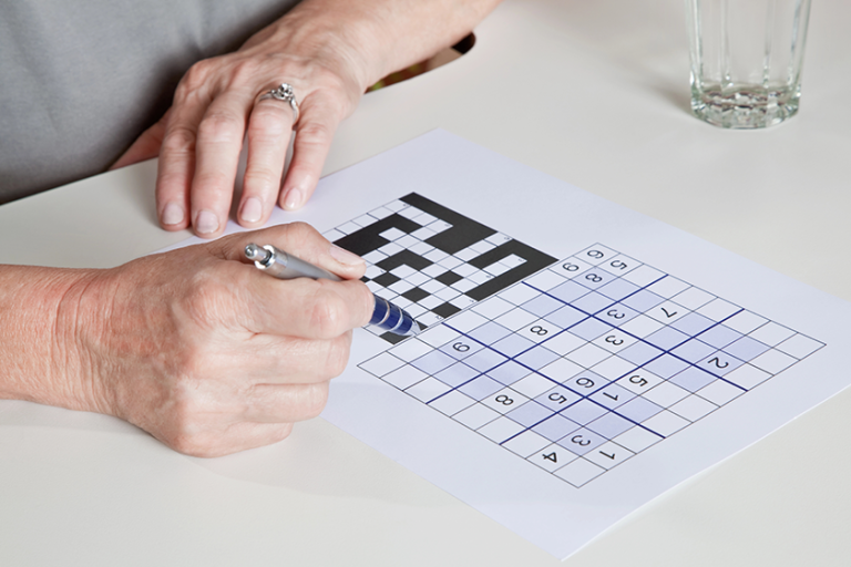 mature woman playing sudoku puzzle