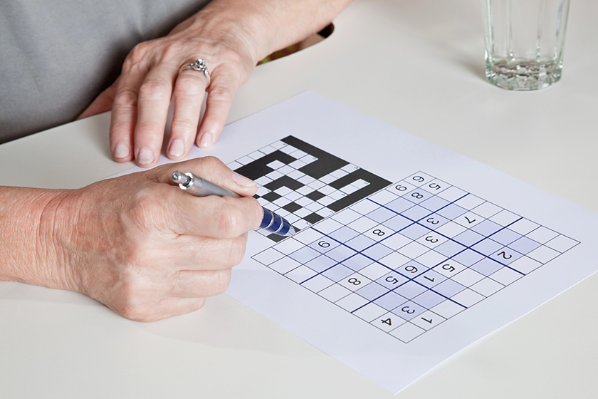 mature woman playing sudoku puzzle