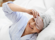 old age and people concept happy smiling senior woman with eye sleeping mask
