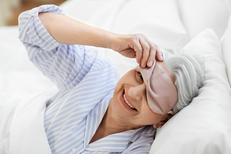 old age and people concept happy smiling senior woman with eye sleeping mask