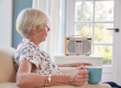 senior woman drinking tea listening radio