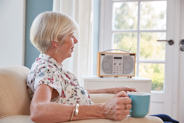 senior woman drinking tea listening radio